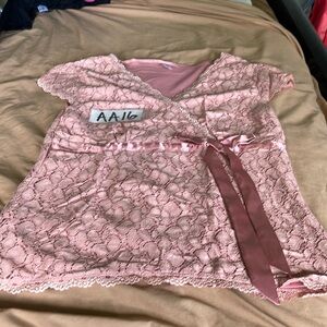This is a lacy pink top with a pink ribbon.